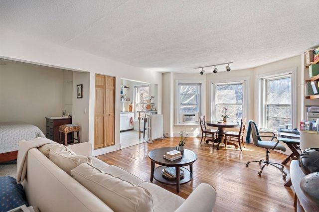 a living room with furniture wooden floor and a window