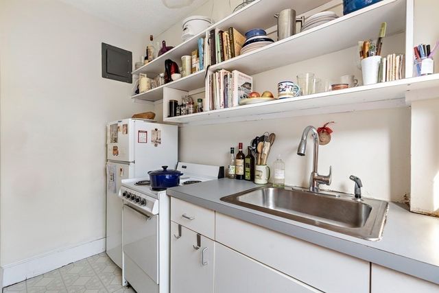 a kitchen with a sink and a stove top oven with a dishwasher