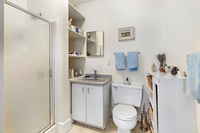a bathroom with a granite countertop toilet sink and mirror
