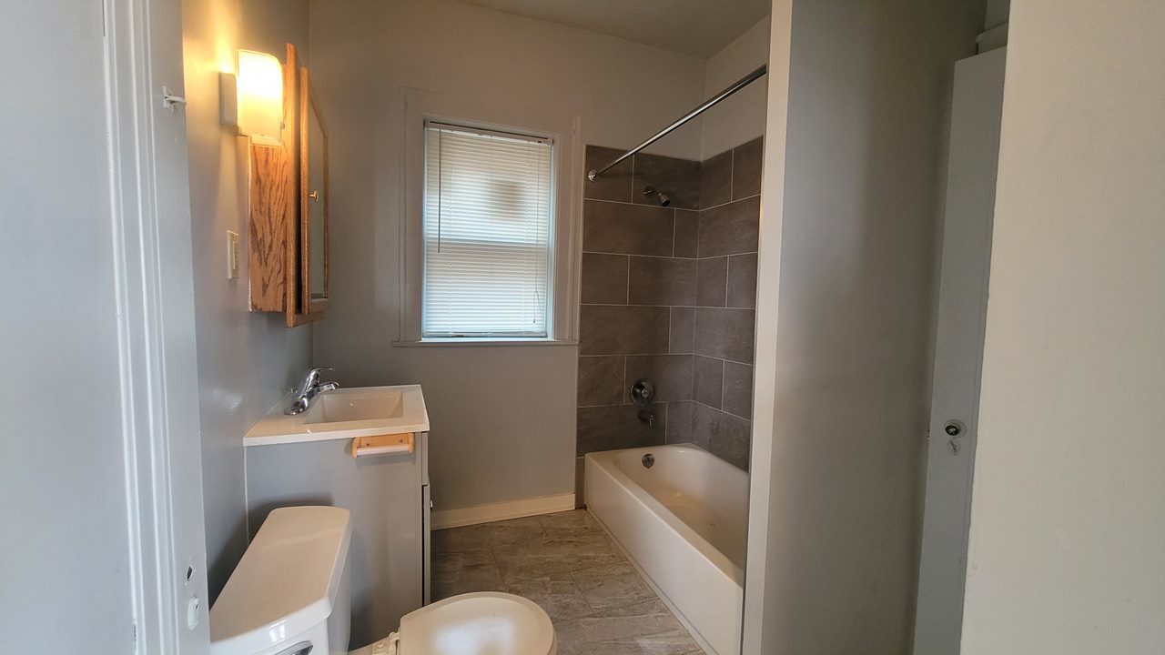 7842 South Bennett Avenue, Unit 2 Chicago, IL 60649 - Photo 2 of 7 a bathroom with a sink mirror bathtub and toilet