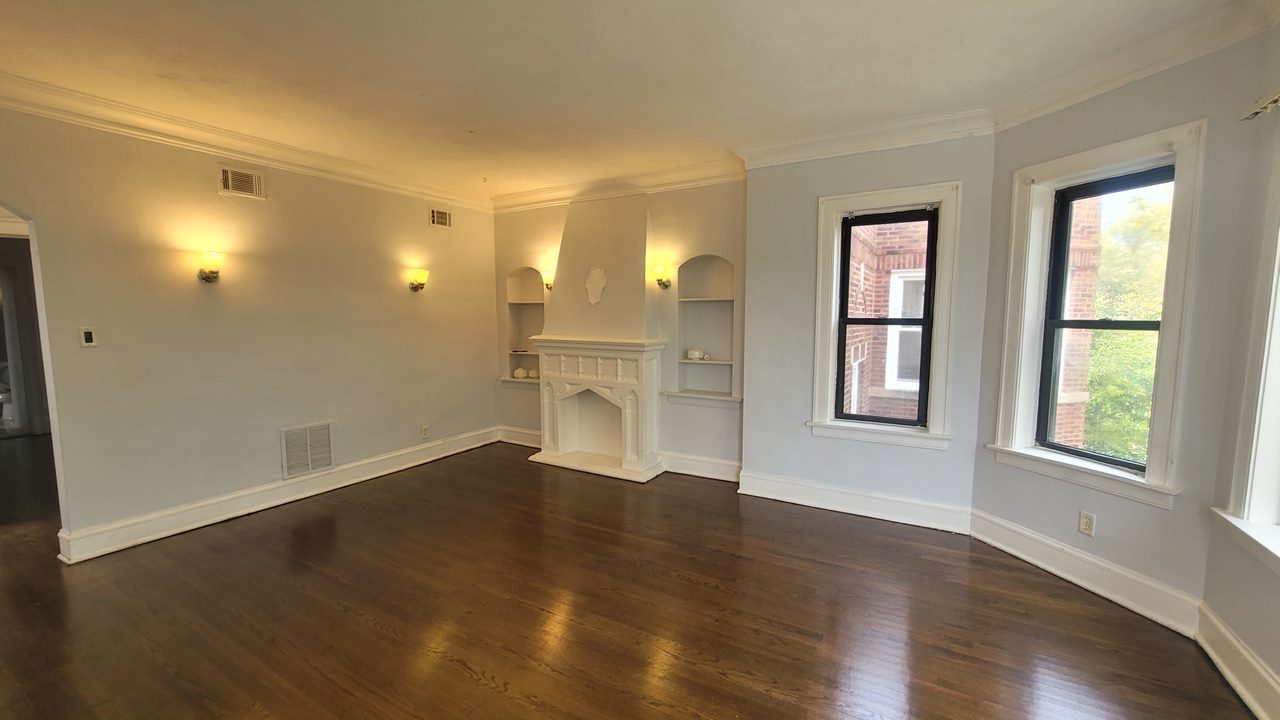 7842 South Bennett Avenue, Unit 2 Chicago, IL 60649 - Photo 5 of 7 an empty room with wooden floor and windows