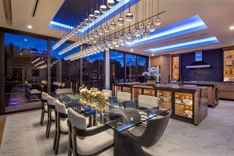 a dining room with furniture large windows and wooden floor