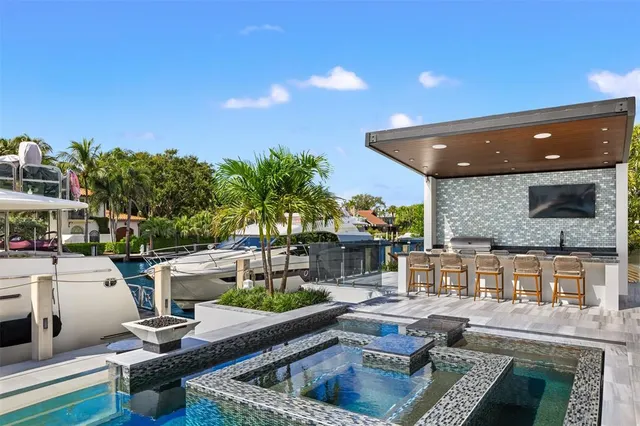 a view of a patio with couches table and chairs with wooden floor and fence