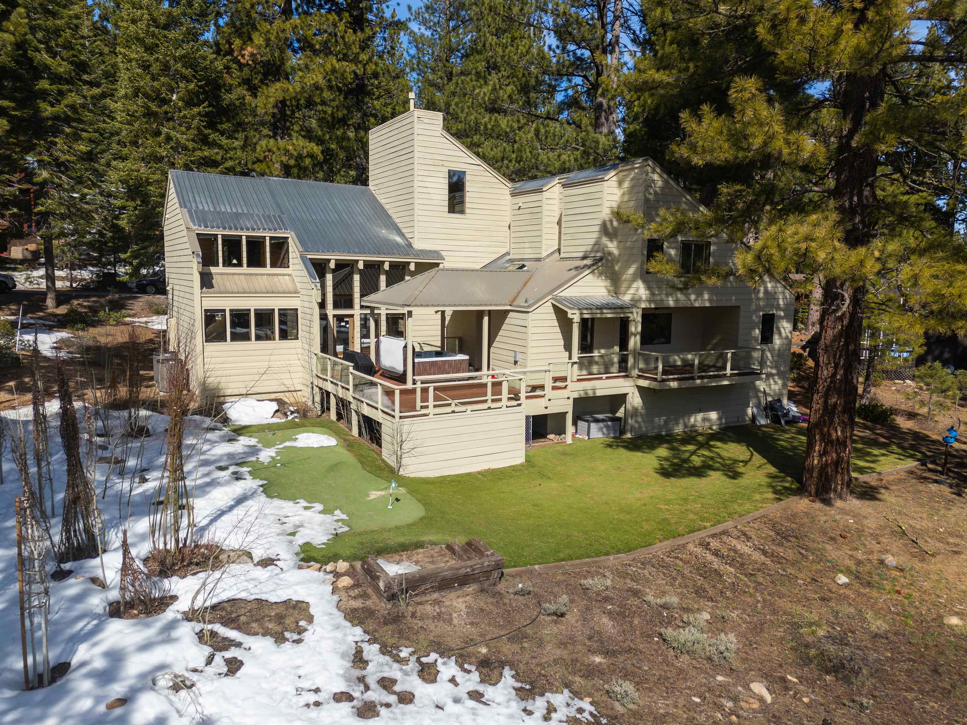 519 Wolf Tree Truckee, CA 96161 - Photo 12 of 22 a view of a white house with a yard table and chairs under an umbrella