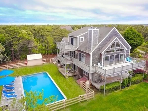 an aerial view of a house with a big yard and large trees