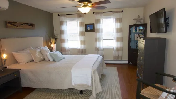 a bedroom with a large bed and a flat screen tv