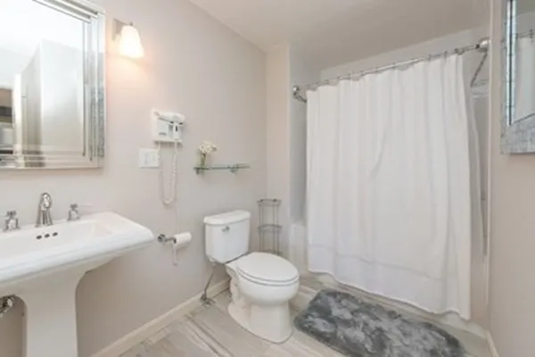 a bathroom with a sink a toilet and shower