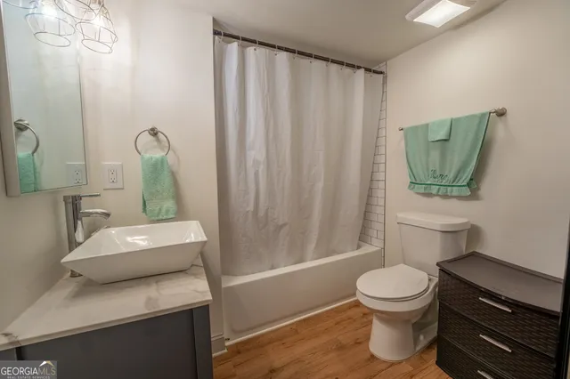 a bathroom with a toilet a sink and tub