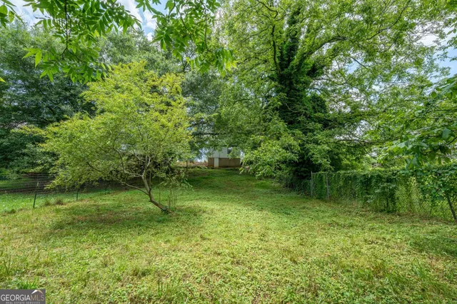 a backyard of a house with lots of green space and lake view