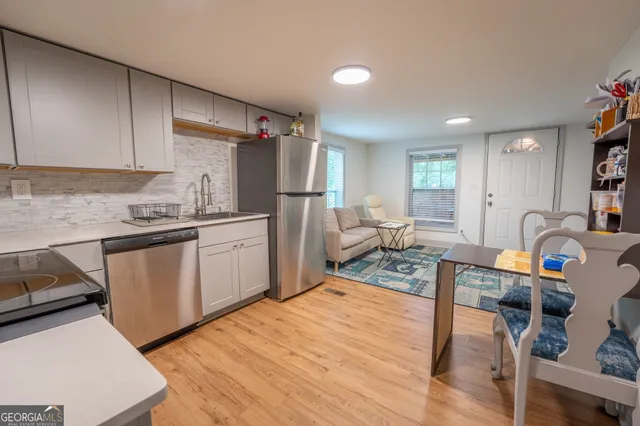 a kitchen with a sink a stove cabinets and wooden floor