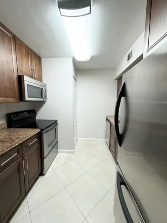 a kitchen with granite countertop a stove a sink and a microwave