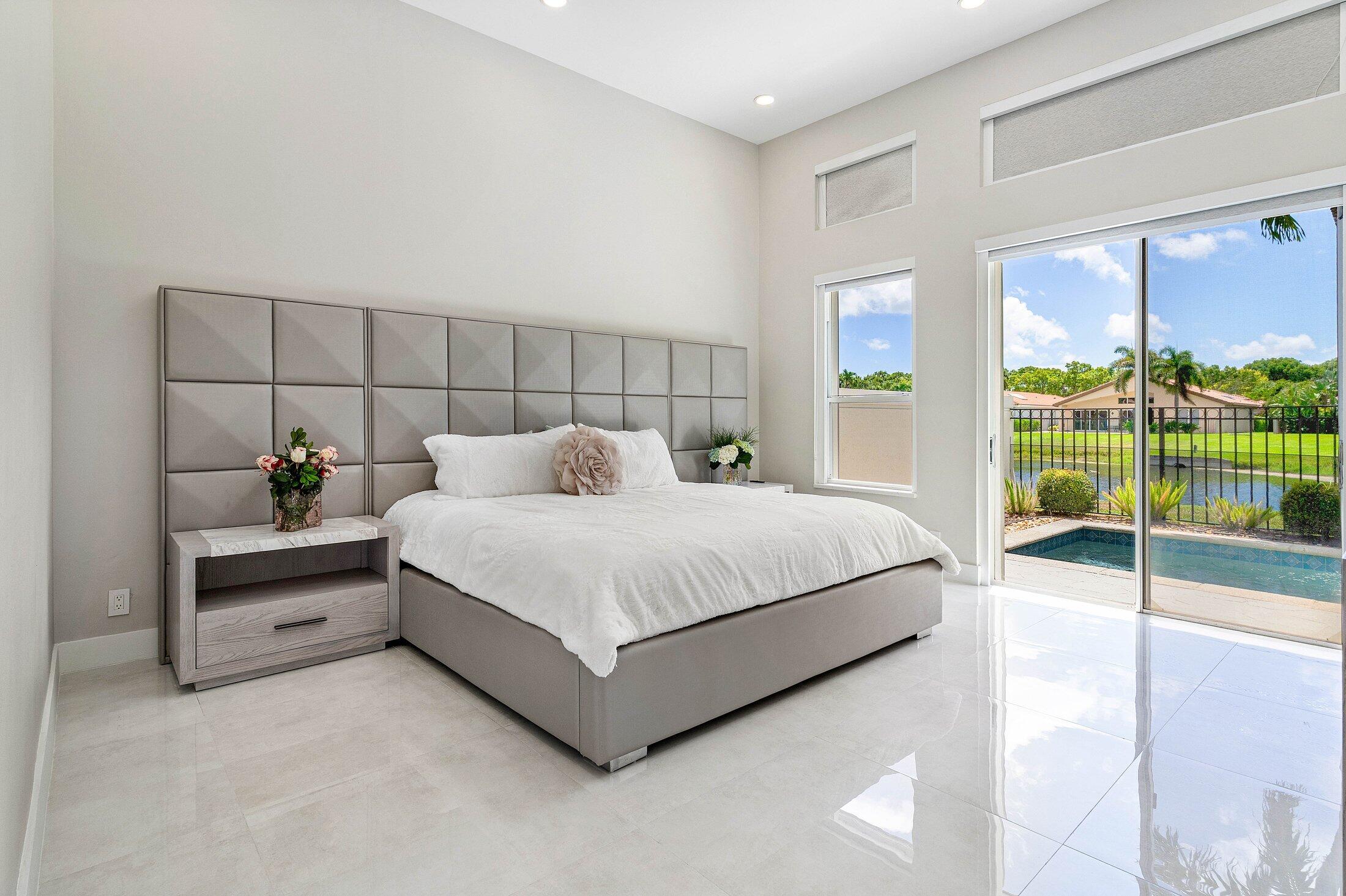 6334 Northwest 24th Street Boca Raton, FL 33434 - Photo 22 of 56 a bed sitting in a spacious bedroom next to a window