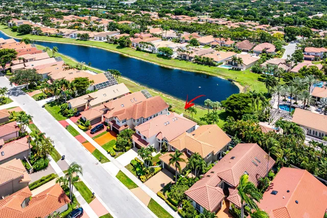 a view of a lake with a house swimming pool a yard and a garden