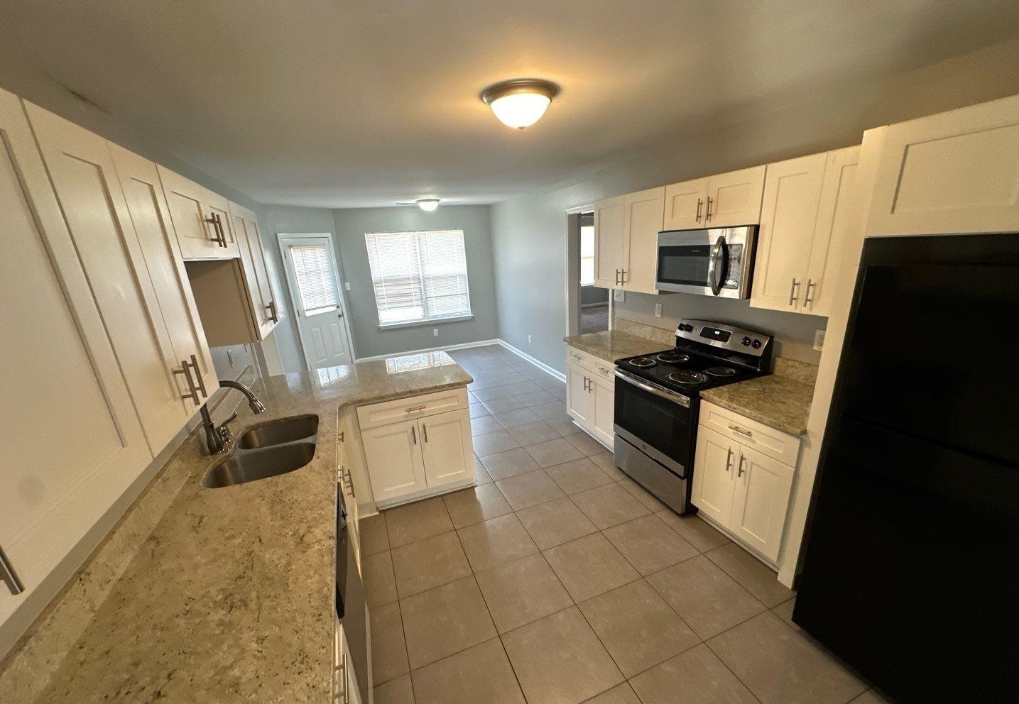 9420 Grove Road Cordova, TN 38016 - Photo 5 of 15 Kitchen with stainless steel appliances, white cabinets, light stone countertops, light tile patterned flooring, and a peninsula
