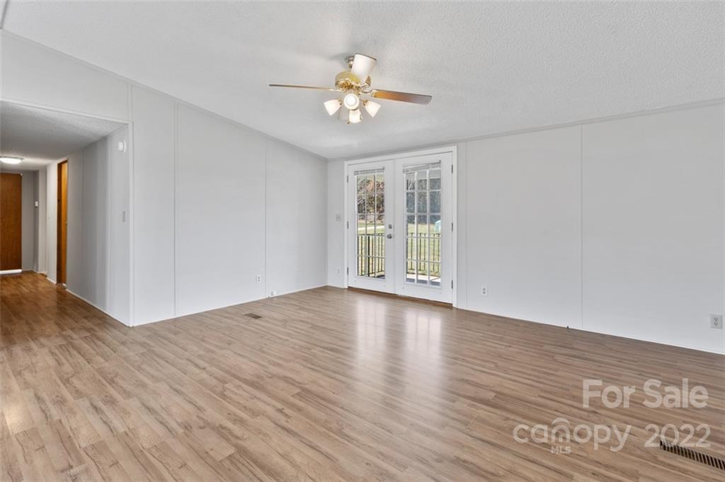 7237 Long Island Road Catawba, NC 28609 - Photo 8 of 36 a view of an empty room with wooden floor and a ceiling fan