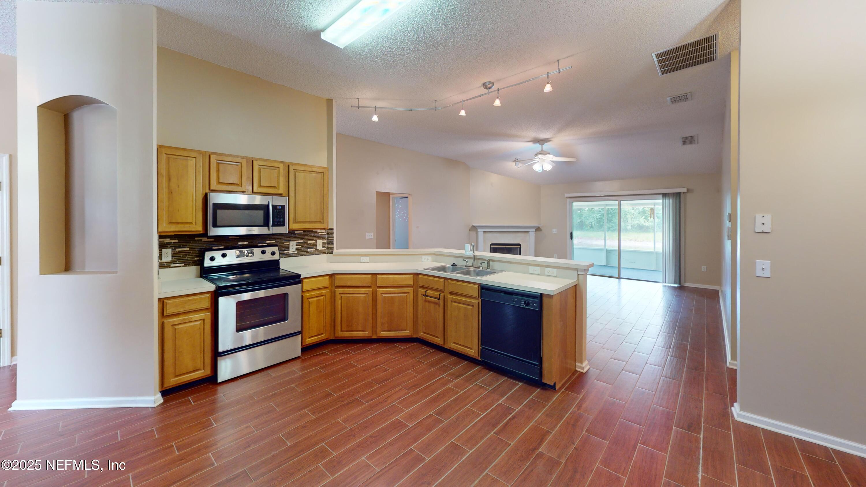 2933 Turning Leaf Lane Jacksonville, FL 32221 - Photo 3 of 22 a large kitchen with wooden floors and stainless steel appliances