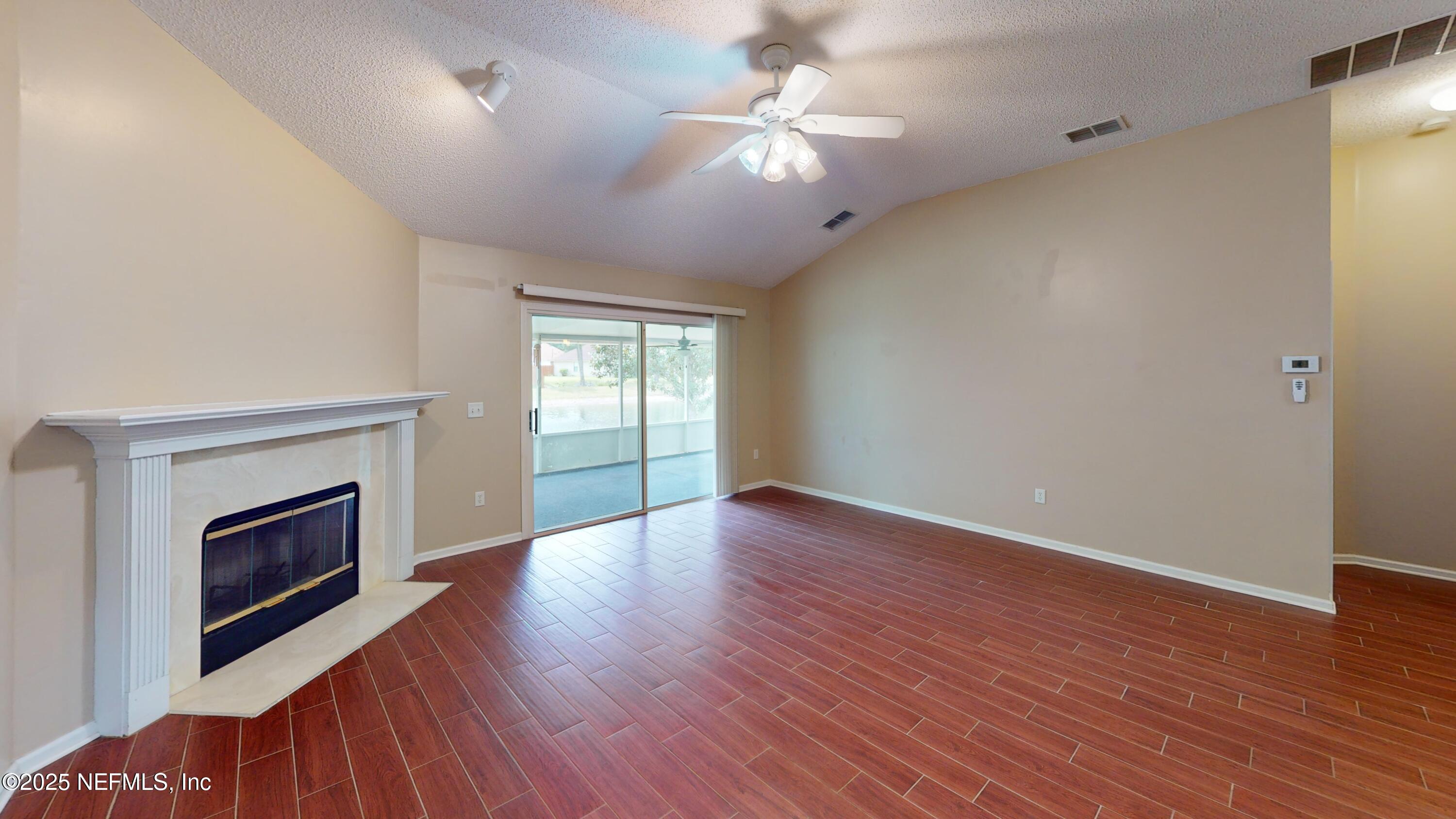 2933 Turning Leaf Lane Jacksonville, FL 32221 - Photo 6 of 22 an empty room with wooden floor fan and windows