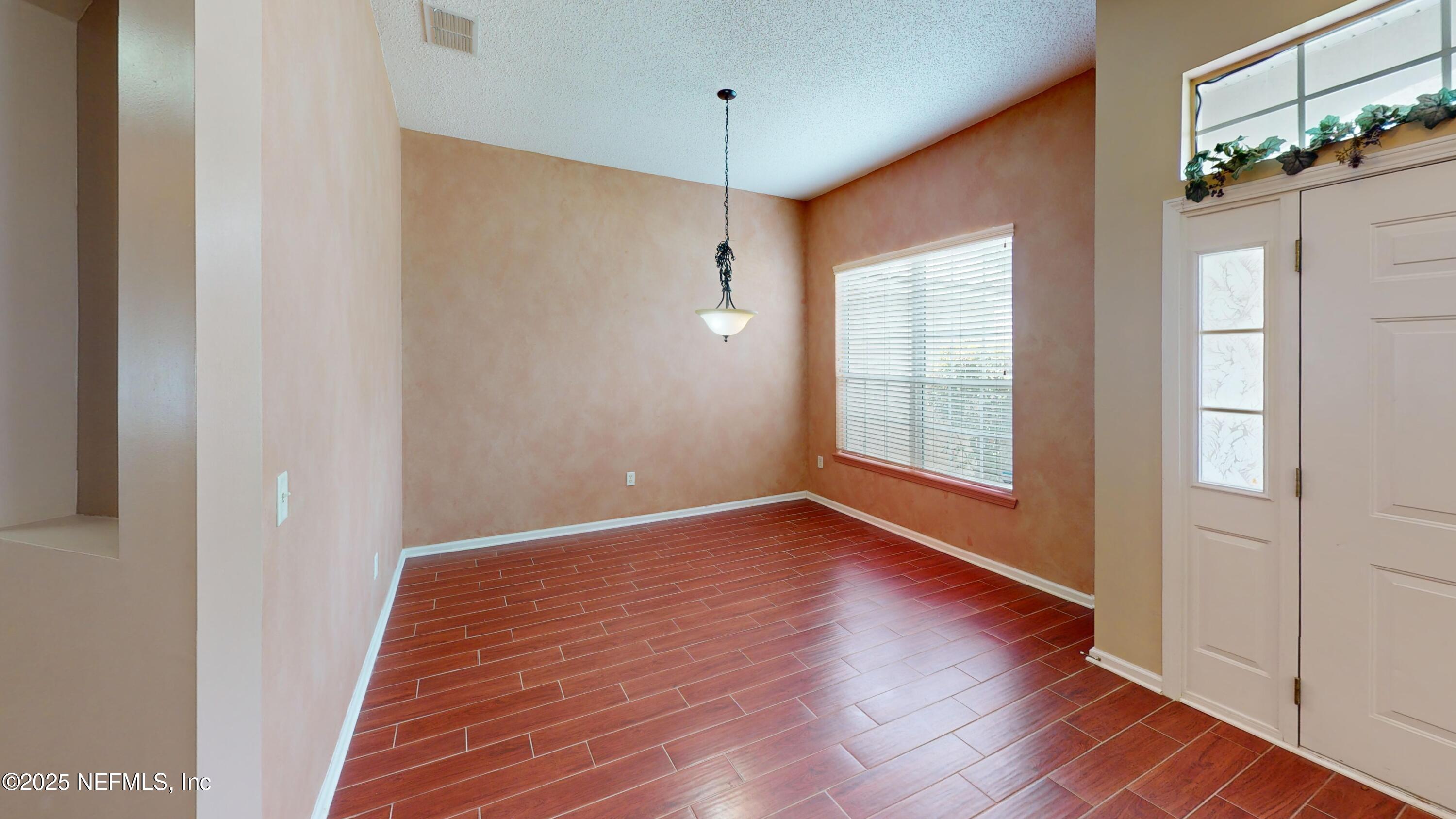 2933 Turning Leaf Lane Jacksonville, FL 32221 - Photo 8 of 22 a view of an empty room with wooden floor and a window