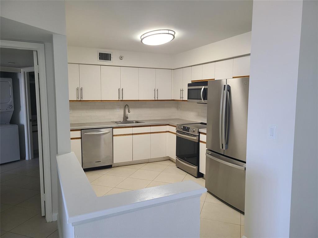 3530 Mystic Pointe Drive, Unit 2707 Aventura, FL 33180 - Photo 4 of 11 a kitchen with a white stainless steel appliances and refrigerator
