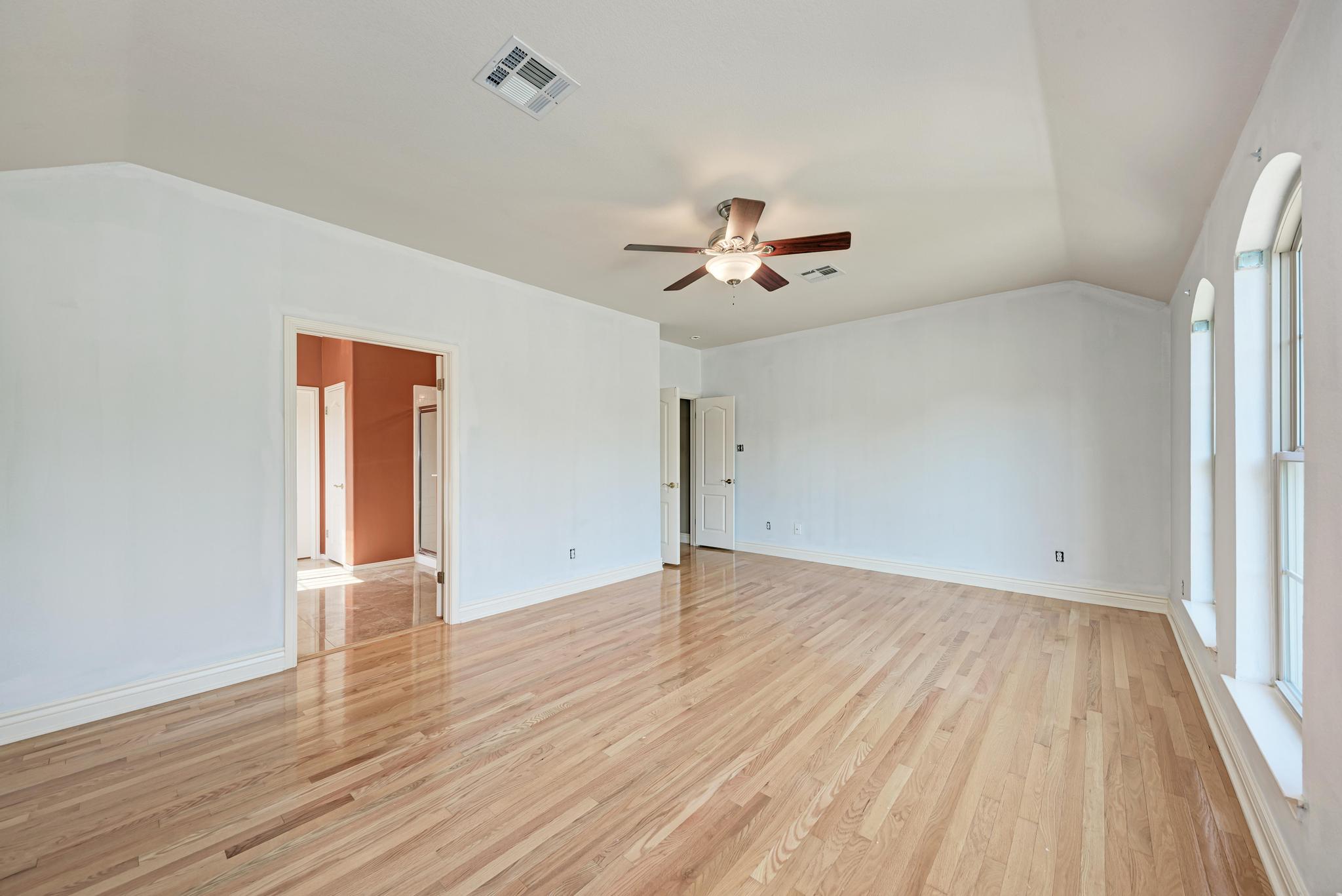 906 Antelope Ridge Cedar Park, TX 78613 - Photo 25 of 40 Polished wood floors and high arched windows define this spacious bedroom interior.