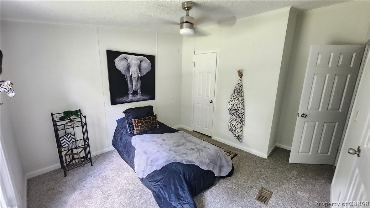 8065 Filly Run Road Gloucester, VA 23061 - Photo 20 of 33 Carpeted bedroom with ceiling fan and a textured ceiling