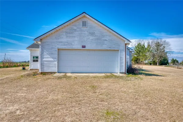 a view of yellow house with a yard and garage