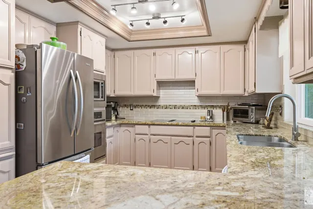 a kitchen with stainless steel appliances granite countertop a refrigerator sink and cabinets