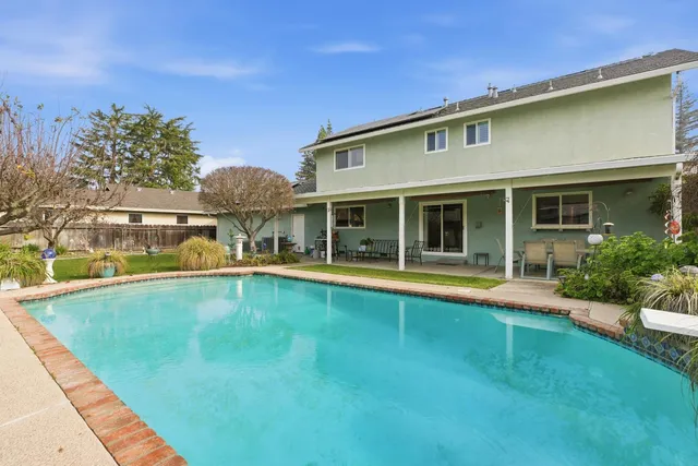 a view of pool with outdoor seating and a yard