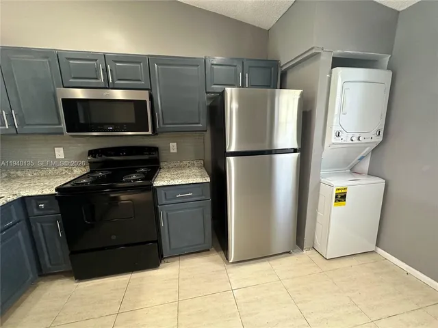 a kitchen with a refrigerator and a stove top oven