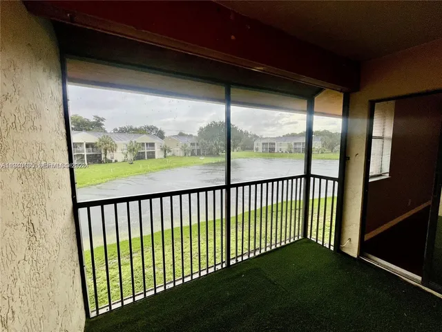 a view of a porch with wooden floor and a backyard