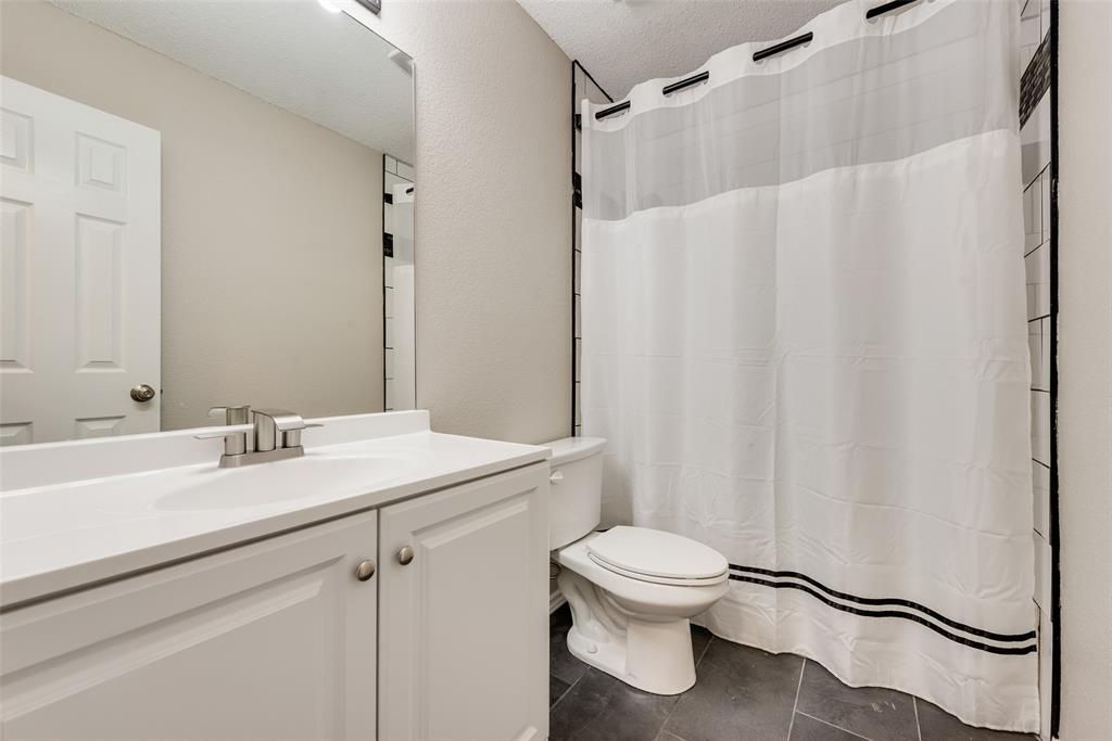 617 Madeline Court Azle, TX 76020 - Photo 20 of 20 Bathroom featuring a shower with shower curtain, vanity, dark tile patterned flooring, and a textured ceiling