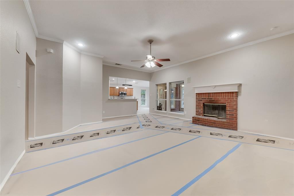 617 Madeline Court Azle, TX 76020 - Photo 4 of 20 Unfurnished living room featuring a fireplace, a ceiling fan, crown molding, and recessed lighting