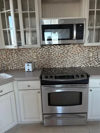 a kitchen with granite countertop white cabinets and stainless steel appliances