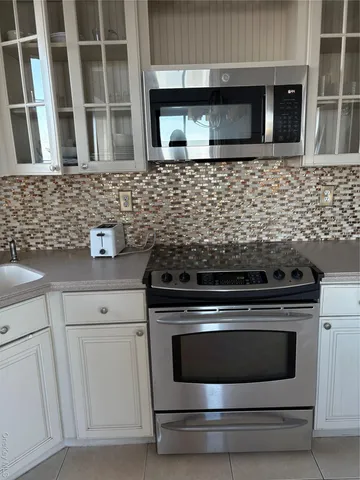 a kitchen with granite countertop white cabinets and stainless steel appliances
