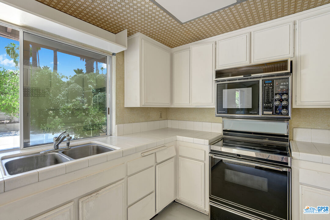 2189 East Sonora Road Palm Springs, CA 92264 - Photo 13 of 29 a kitchen with stainless steel appliances a stove sink and microwave