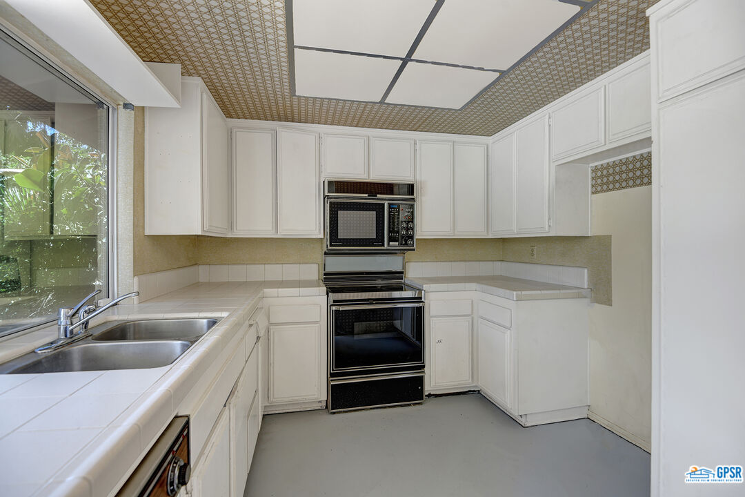 2189 East Sonora Road Palm Springs, CA 92264 - Photo 14 of 29 a kitchen with granite countertop a stove sink and microwave