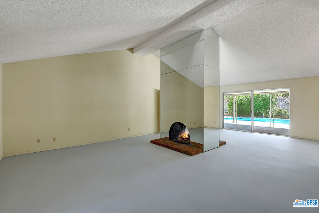 2189 East Sonora Road Palm Springs, CA 92264 - Photo 5 of 29 a living room with furniture and a floor to ceiling window