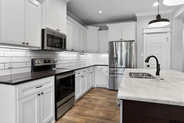 a kitchen with stainless steel appliances granite countertop a sink stove and refrigerator