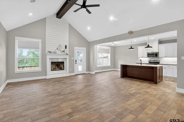an empty room with wooden floor and a ceiling fan