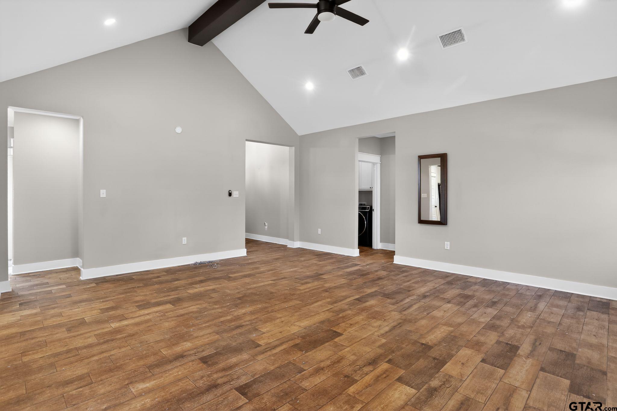 7600 County Road 210 Tyler, TX 75702 - Photo 8 of 30 an empty room with wooden floor and a ceiling fan