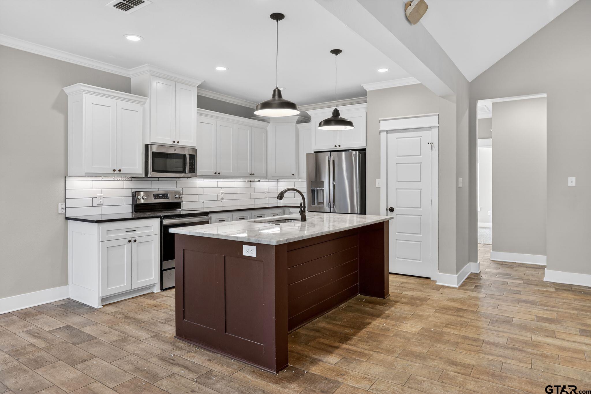 7600 County Road 210 Tyler, TX 75702 - Photo 9 of 30 a kitchen with kitchen island a sink stainless steel appliances and cabinets