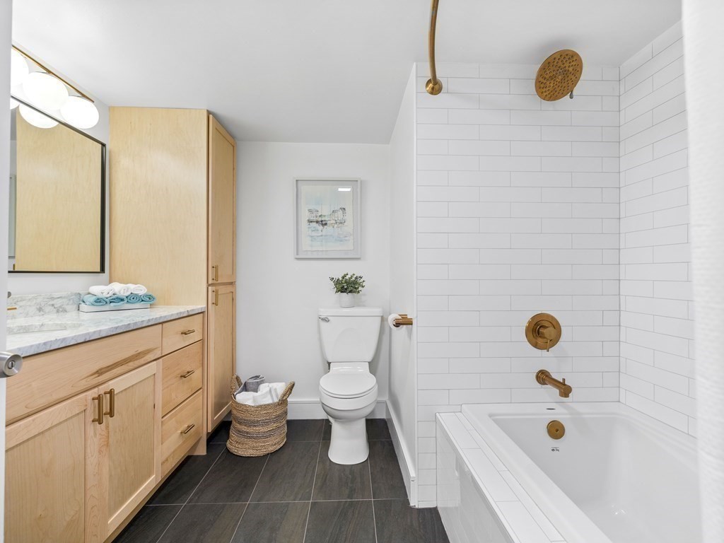 2 Boylston Street, Unit 4 Boston, MA 02130 - Photo 18 of 30 a bathroom with a granite countertop bathtub sink vanity mirror and toilet
