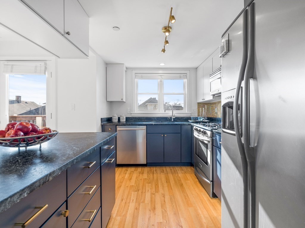2 Boylston Street, Unit 4 Boston, MA 02130 - Photo 8 of 30 a kitchen with stainless steel appliances granite countertop a sink refrigerator and cabinets