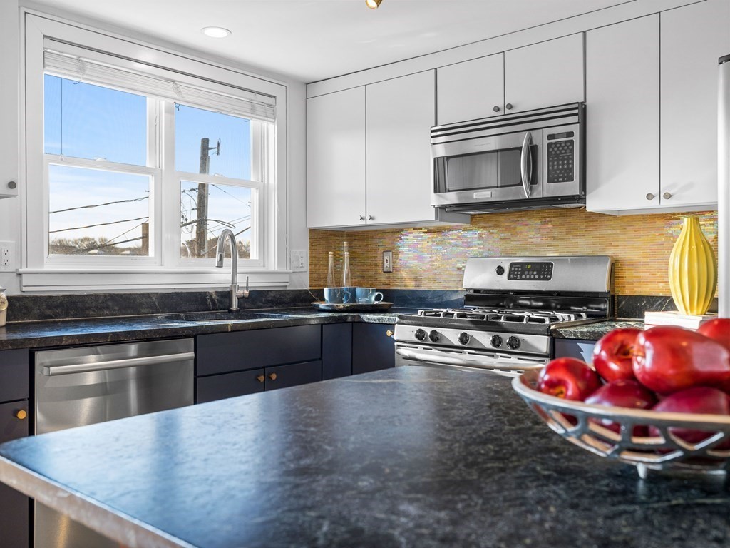 2 Boylston Street, Unit 4 Boston, MA 02130 - Photo 9 of 30 a kitchen with stainless steel appliances a stove a sink and a microwave
