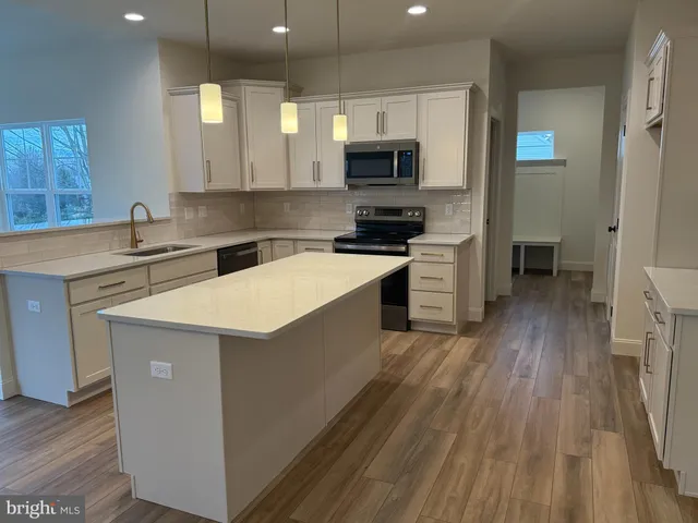 a kitchen with a sink a stove and cabinets