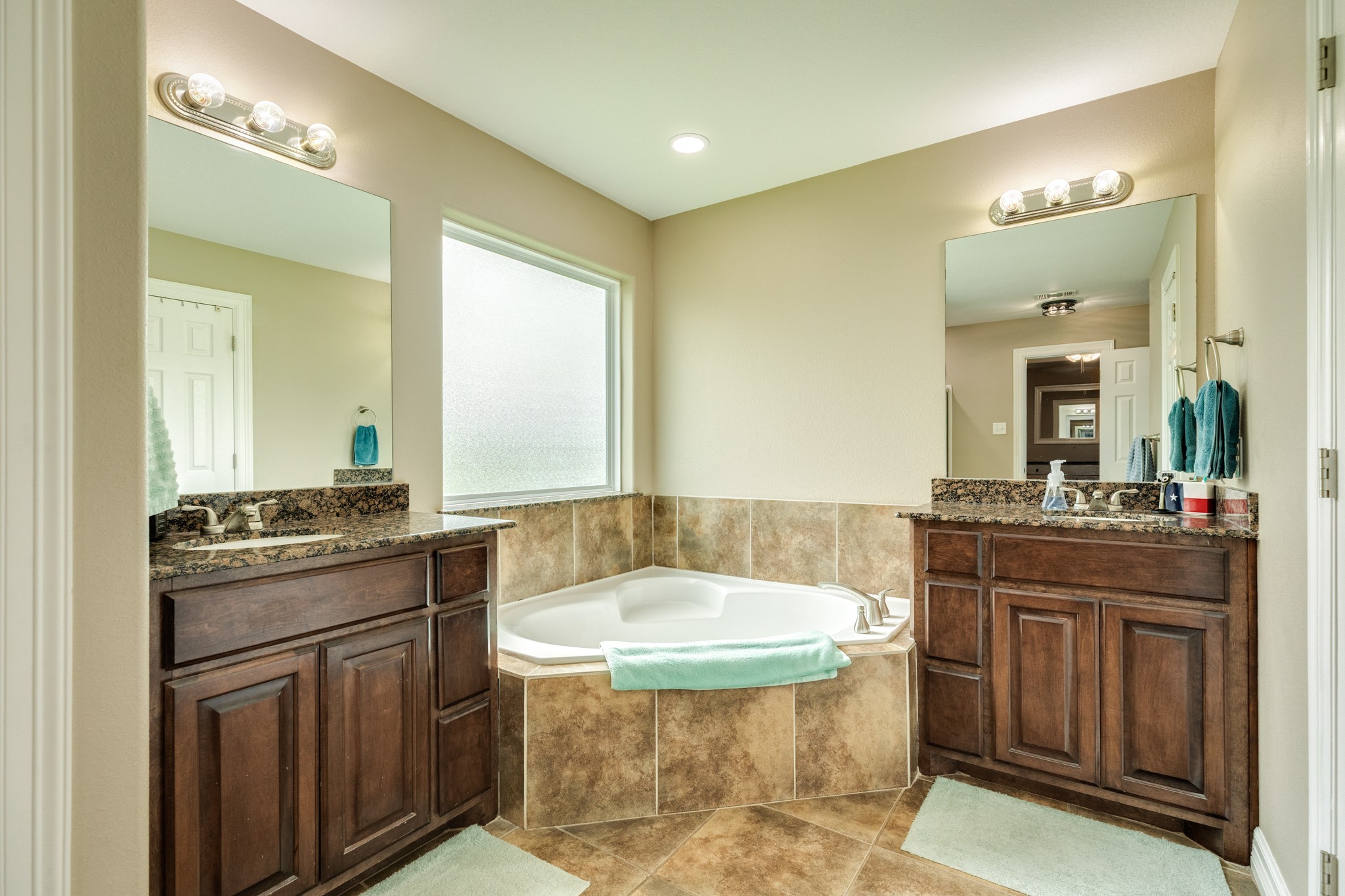 6108 Fox Ridge Drive Angleton, TX 77515 - Photo 15 of 26 a bathroom with a granite countertop sink a mirror and a bathtub