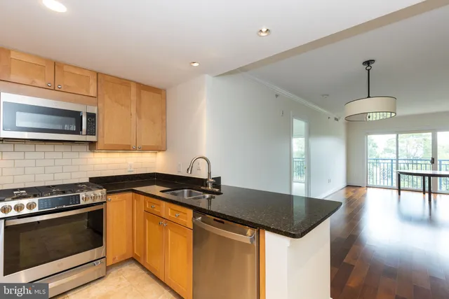a kitchen with granite countertop a sink appliances and cabinets