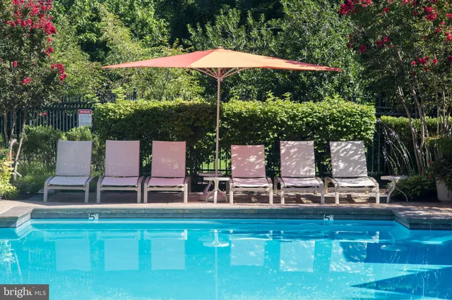 a roof deck with table and chairs under an umbrella