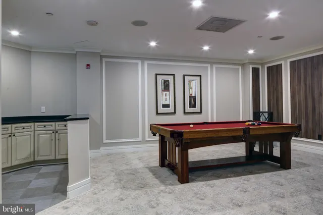 a room with furniture pool table and chairs