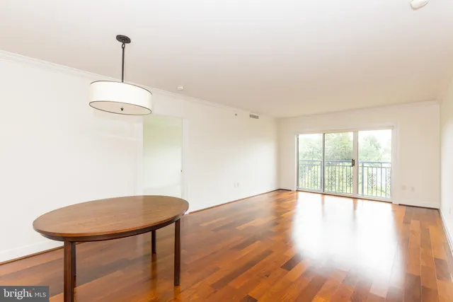 a view of a room with wooden floor table and chairs